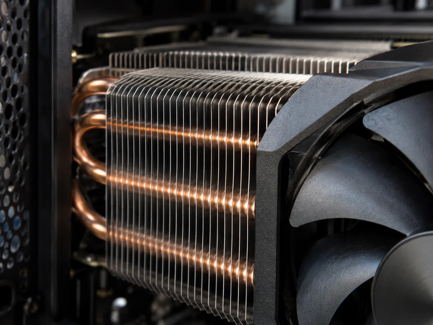 Close-up of aluminium heatsink fins and a cooling fan inside a computer case